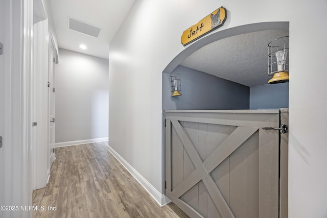 corridor with hardwood / wood-style flooring