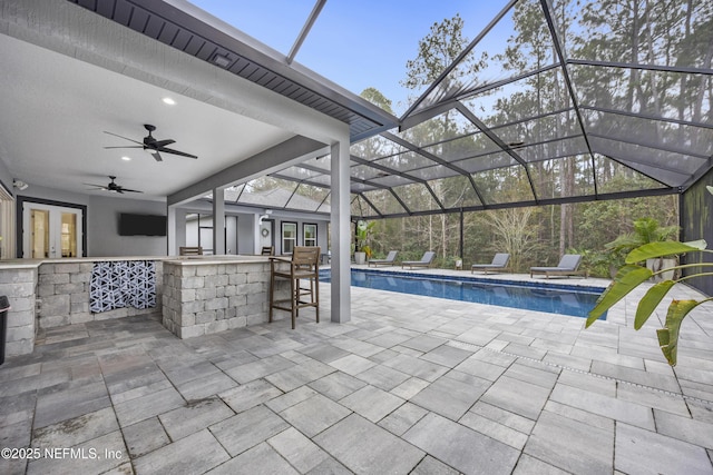 exterior space featuring a patio area, a lanai, a bar, and ceiling fan