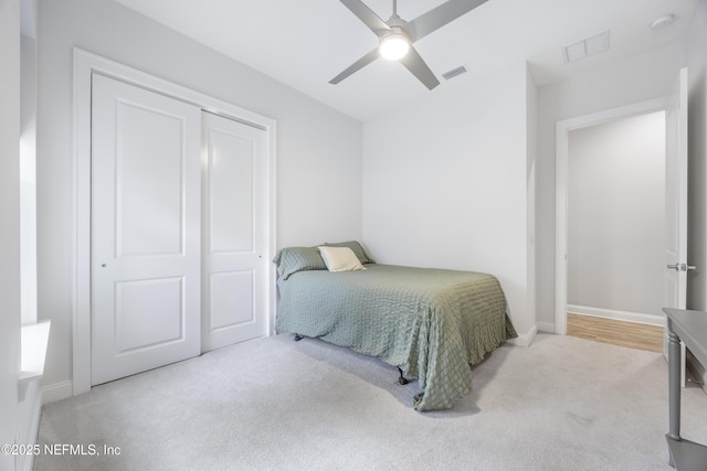 carpeted bedroom with ceiling fan and a closet