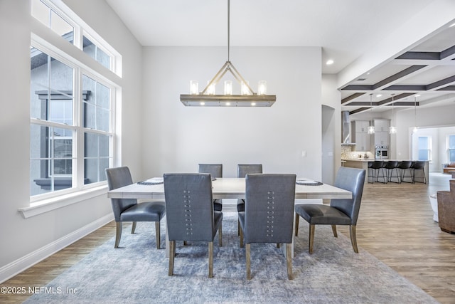 dining room featuring hardwood / wood-style flooring and beamed ceiling