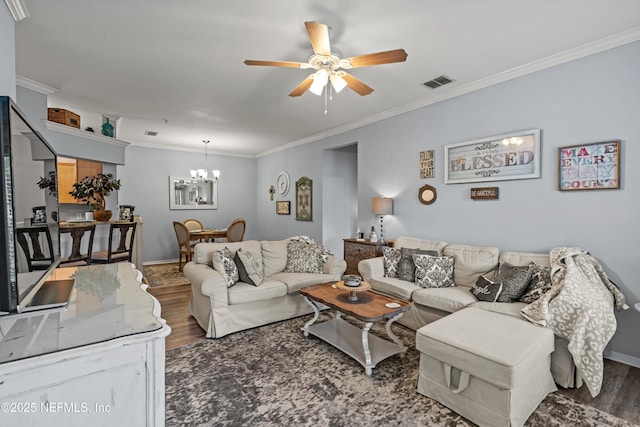 living room featuring ceiling fan with notable chandelier, dark wood-type flooring, and ornamental molding