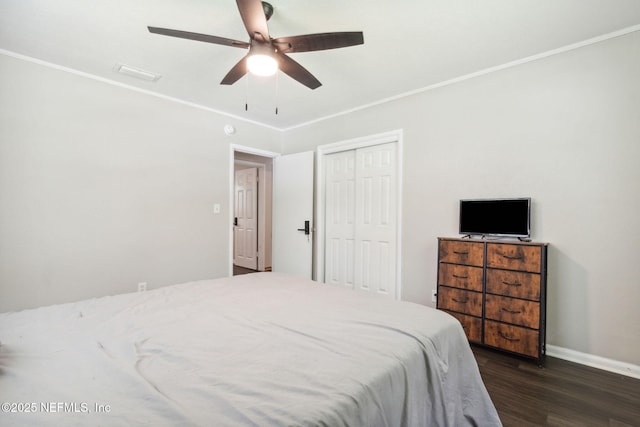 bedroom with ceiling fan, dark hardwood / wood-style floors, crown molding, and a closet