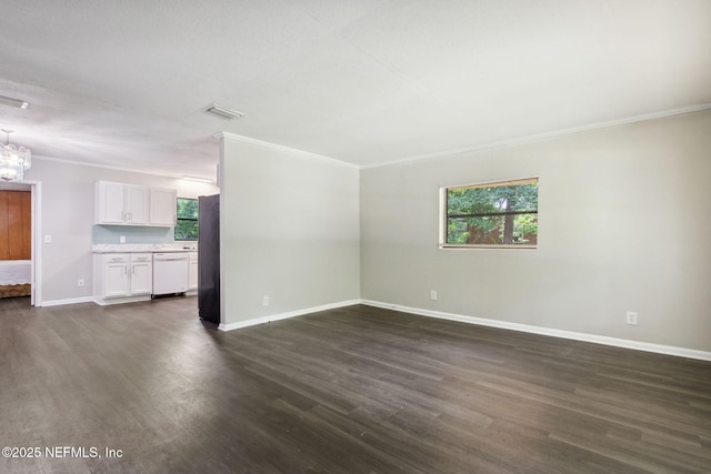 unfurnished living room with dark hardwood / wood-style flooring, crown molding, a wealth of natural light, and a chandelier