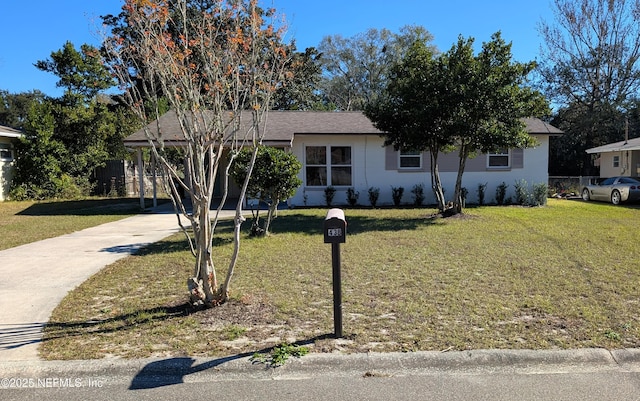 view of front of home with a front yard and a carport