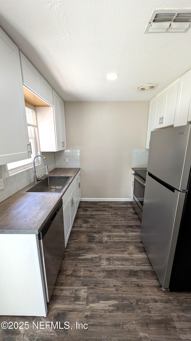 kitchen featuring a textured ceiling, white cabinetry, sink, and appliances with stainless steel finishes