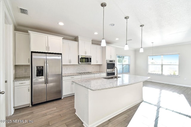 kitchen featuring appliances with stainless steel finishes, backsplash, pendant lighting, and white cabinetry