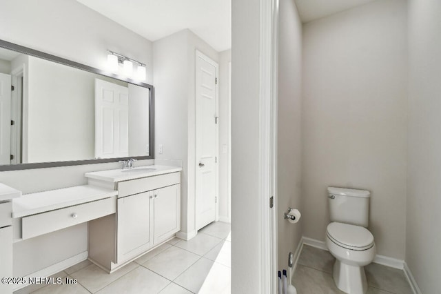 bathroom with tile patterned flooring, vanity, and toilet