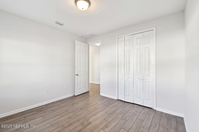 unfurnished bedroom featuring a closet and light hardwood / wood-style flooring