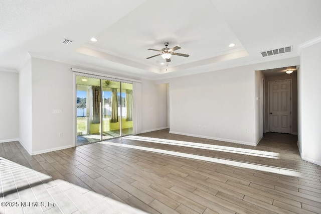 unfurnished room featuring ceiling fan, a tray ceiling, and ornamental molding