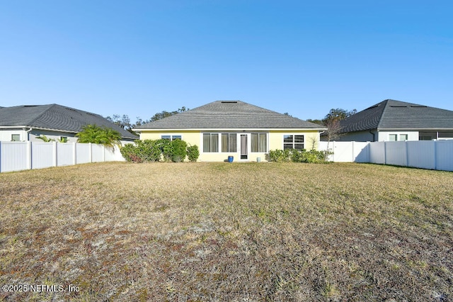 rear view of property with a lawn