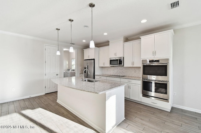 kitchen featuring stainless steel appliances, a center island with sink, white cabinets, and pendant lighting