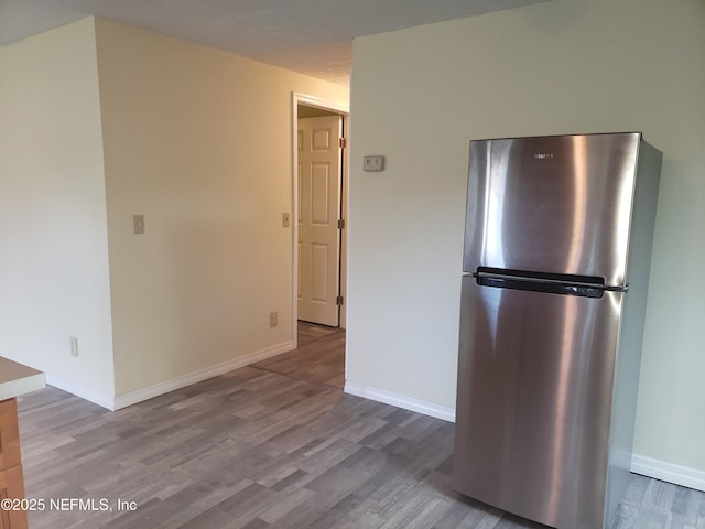 kitchen featuring stainless steel refrigerator and light hardwood / wood-style flooring