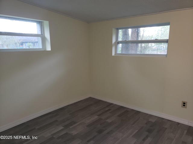 empty room featuring dark hardwood / wood-style floors and ornamental molding