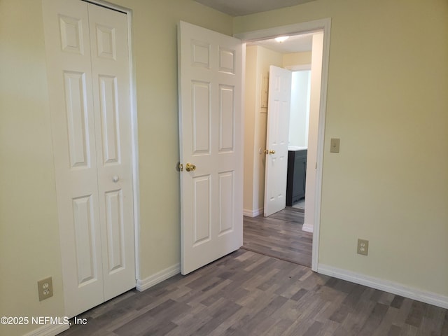 unfurnished bedroom featuring dark hardwood / wood-style floors and a closet