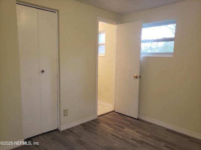 unfurnished bedroom featuring dark hardwood / wood-style flooring and a closet