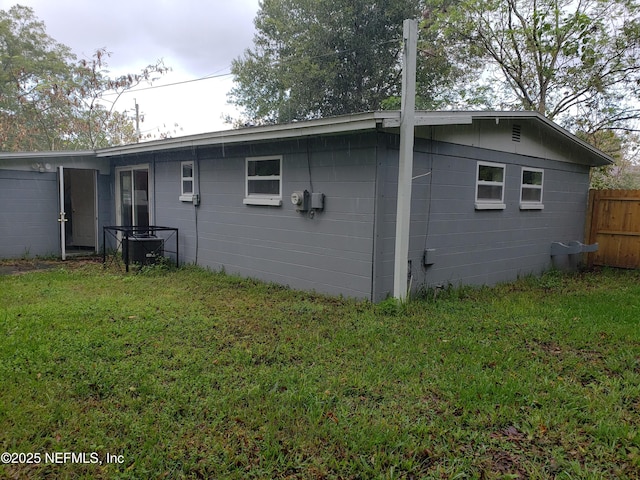 back of house featuring a lawn and cooling unit