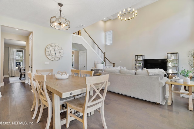 dining space featuring dark wood-type flooring and a notable chandelier