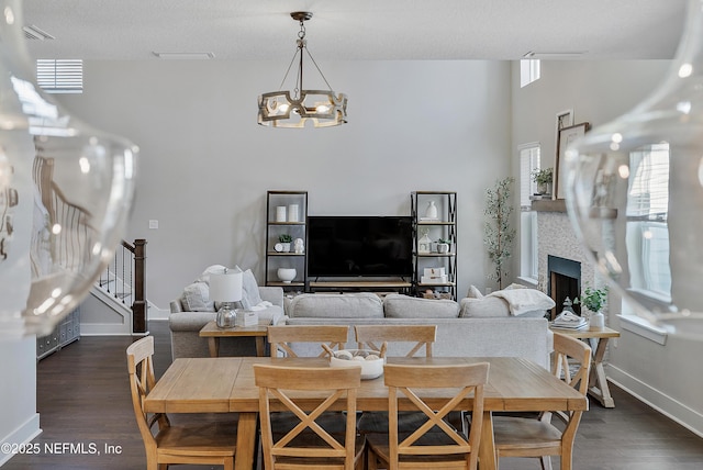 living room with dark wood-type flooring, a textured ceiling, and a notable chandelier