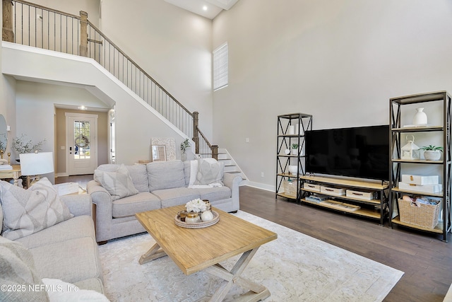 living room featuring hardwood / wood-style floors and a towering ceiling