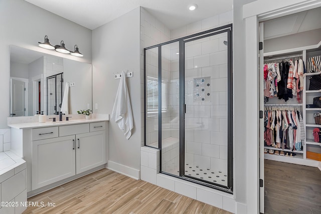 bathroom featuring walk in shower and vanity