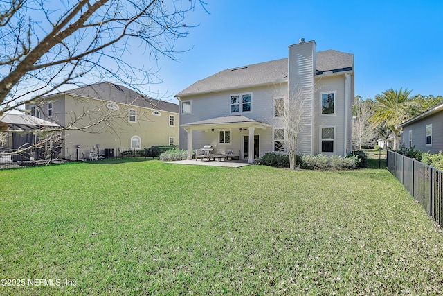 back of house featuring a patio area and a lawn