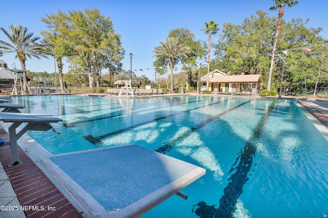 view of swimming pool featuring a diving board