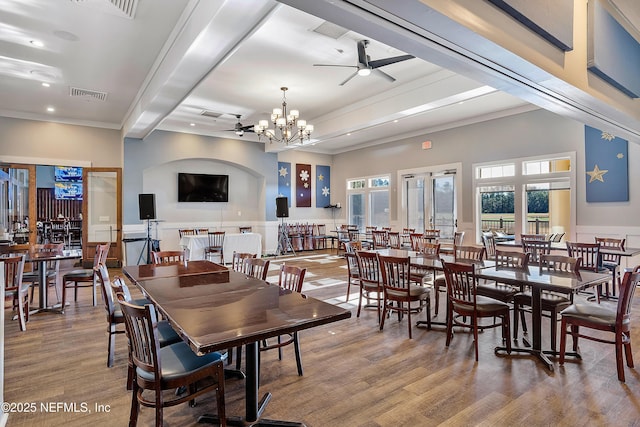 dining space with crown molding, ceiling fan with notable chandelier, hardwood / wood-style floors, and beamed ceiling