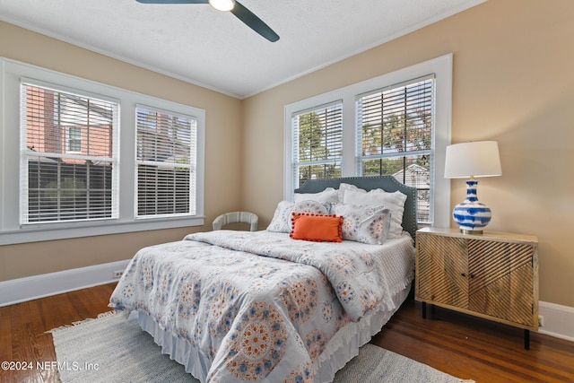 bedroom featuring a textured ceiling, ceiling fan, crown molding, and dark wood-type flooring