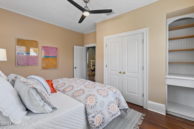 bedroom with ceiling fan, dark hardwood / wood-style flooring, crown molding, a textured ceiling, and a closet