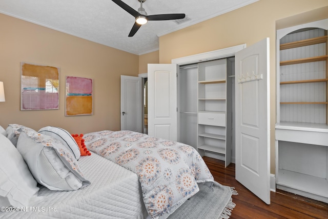 bedroom featuring ceiling fan, dark wood-type flooring, a textured ceiling, a closet, and ornamental molding