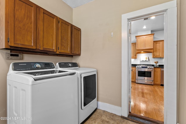 laundry room featuring separate washer and dryer and cabinets