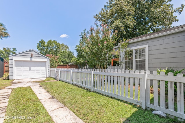 view of yard featuring a garage and an outbuilding