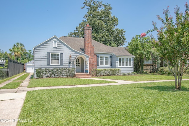 view of front facade with a garage, an outdoor structure, and a front lawn