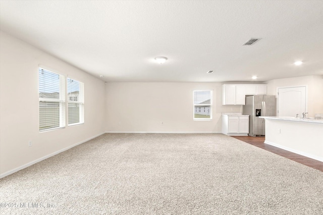 unfurnished living room with a healthy amount of sunlight and sink