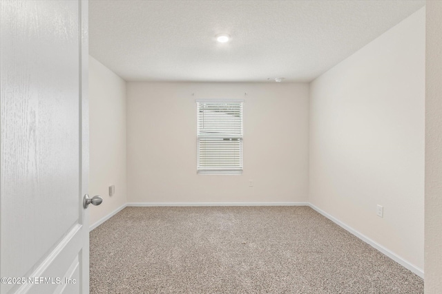 carpeted spare room with a textured ceiling