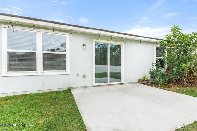 back of property featuring a lawn and a patio area