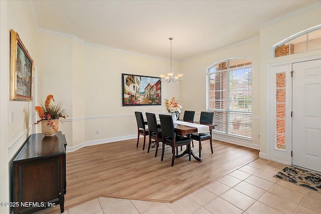 dining room with light tile patterned flooring, an inviting chandelier, and crown molding