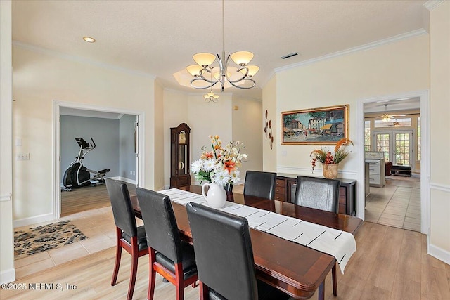 dining area featuring crown molding, french doors, light hardwood / wood-style flooring, and ceiling fan with notable chandelier