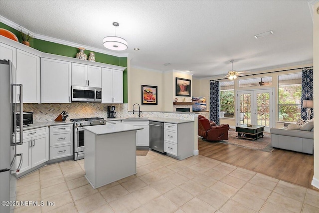 kitchen featuring sink, white cabinets, high quality appliances, and kitchen peninsula