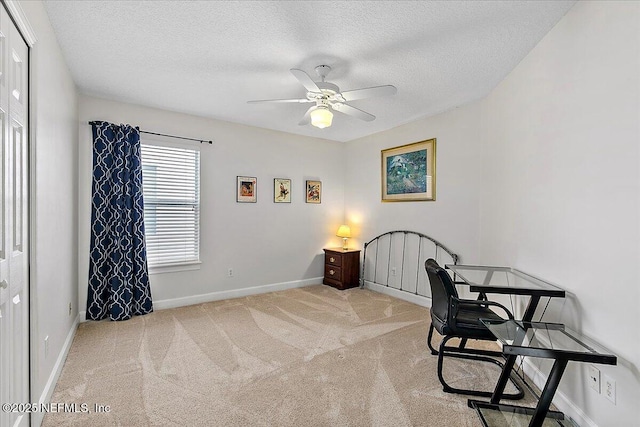 carpeted office with a textured ceiling and ceiling fan