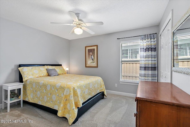 bedroom featuring a textured ceiling, ceiling fan, a closet, and carpet