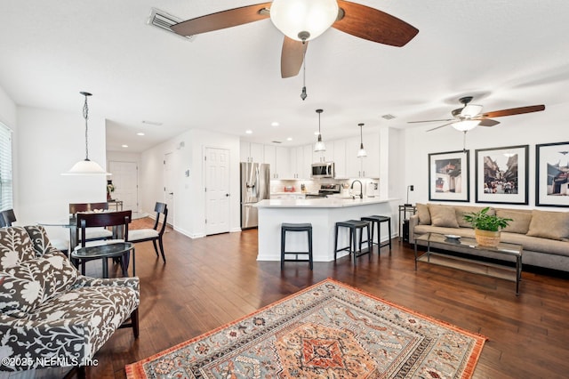 living room featuring dark wood-type flooring and sink