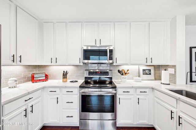 kitchen featuring white cabinetry, appliances with stainless steel finishes, sink, and light stone counters