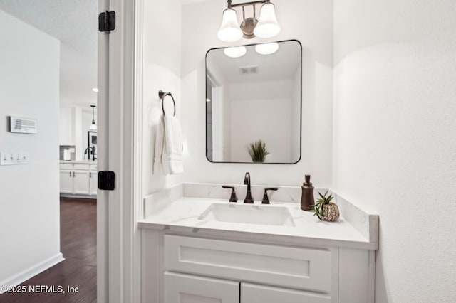 bathroom with vanity, hardwood / wood-style floors, and a notable chandelier