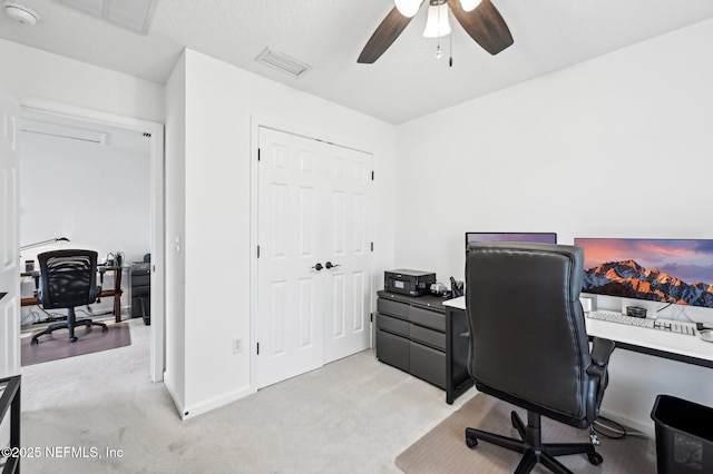 carpeted office space with ceiling fan