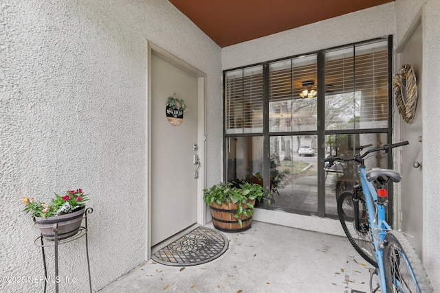 doorway to property featuring stucco siding