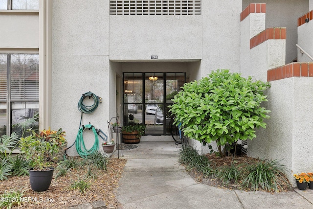 entrance to property featuring stucco siding