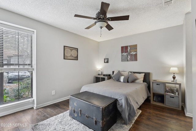 bedroom featuring multiple windows, wood finished floors, visible vents, and a textured ceiling