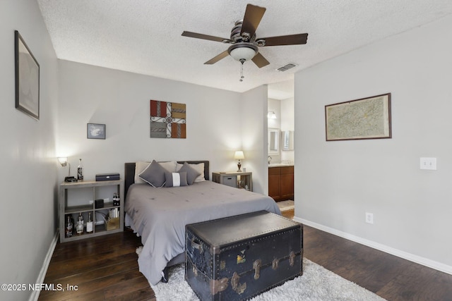 bedroom featuring visible vents, baseboards, a textured ceiling, and wood finished floors