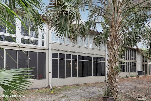 view of side of property featuring cooling unit and a sunroom